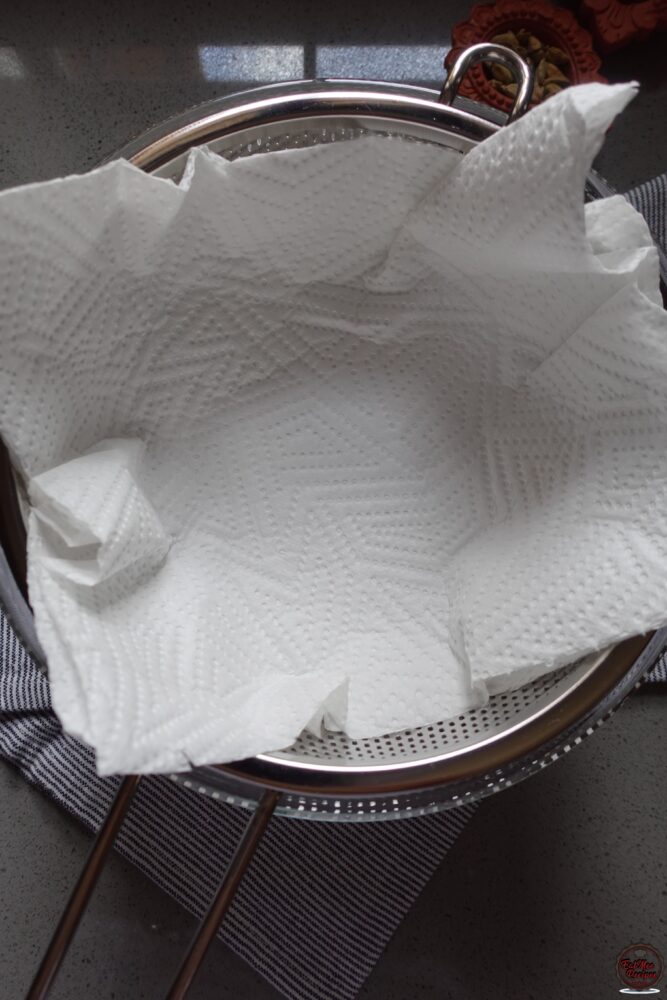 Line a strainer with paper towels & place it over a bowl. This will be used for draining off excess oil.