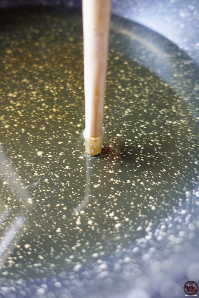 You know the oil is ready when you place the end of a wooden spoon at the surface of the pot & there are bubbles forming around it.