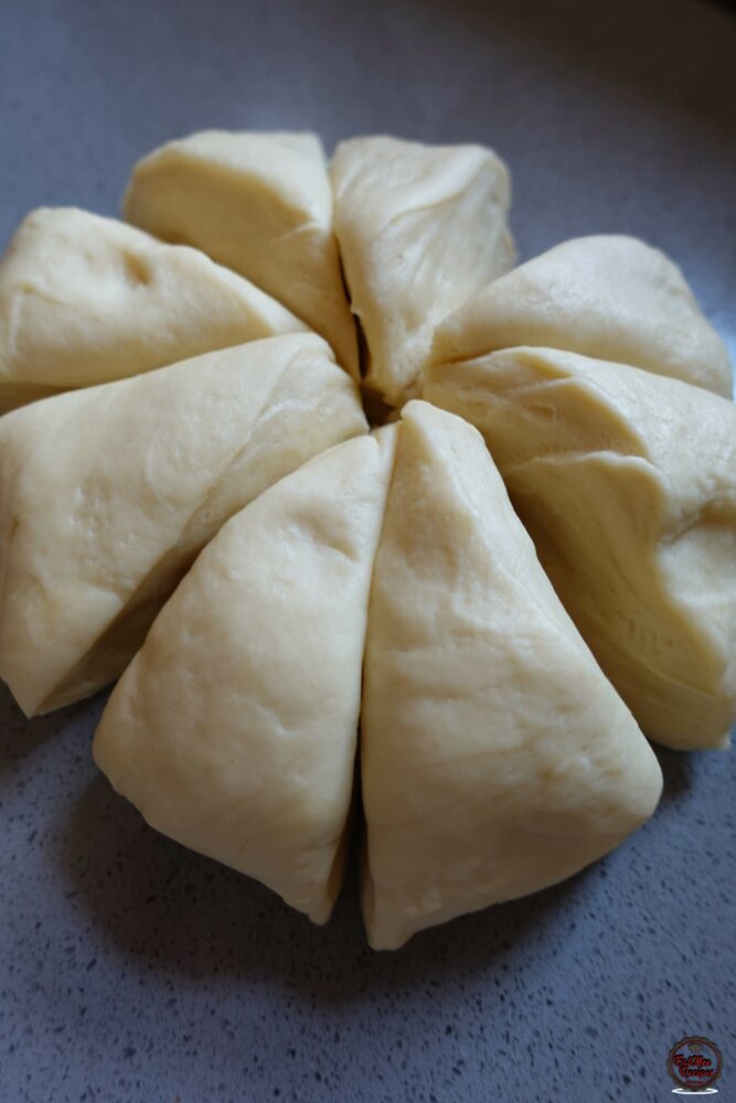 Place the dough onto a working surface & cut into 8 equal parts.