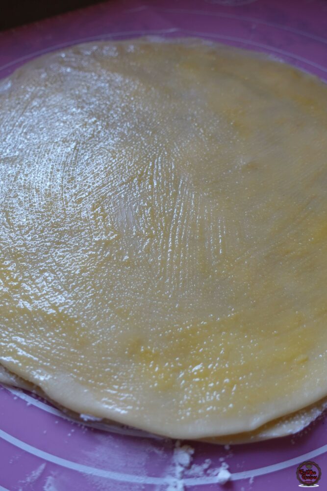 Repeat the process by brushing with ghee, dusting with corn flour & placing another disc over. 